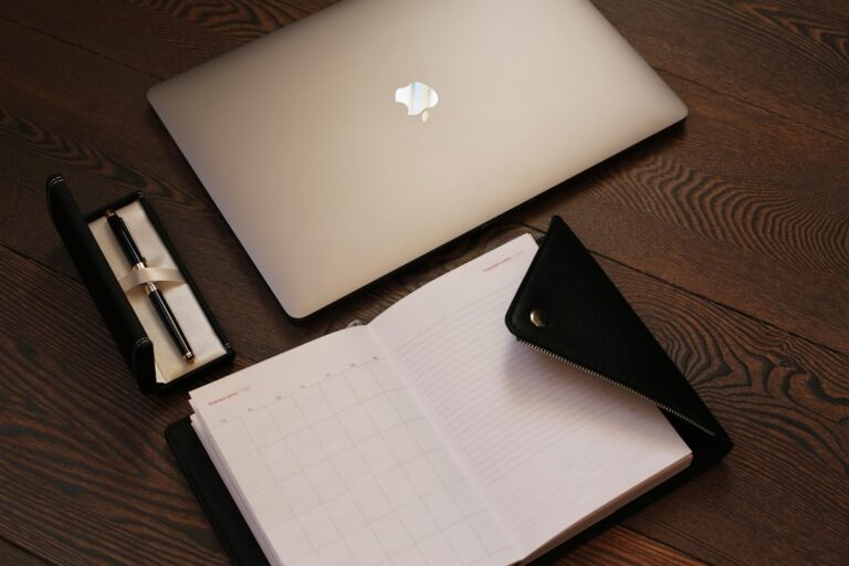 silver macbook on brown table