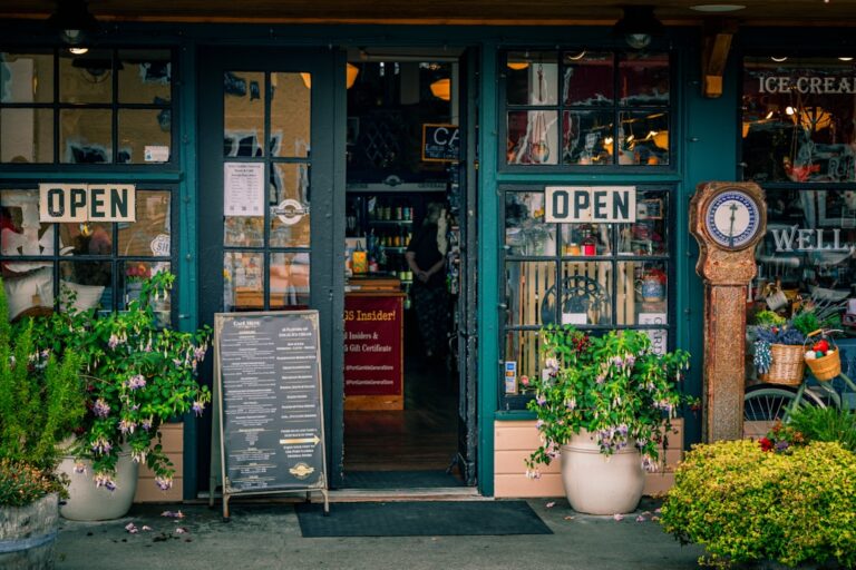 Green storefront with open signs and plants