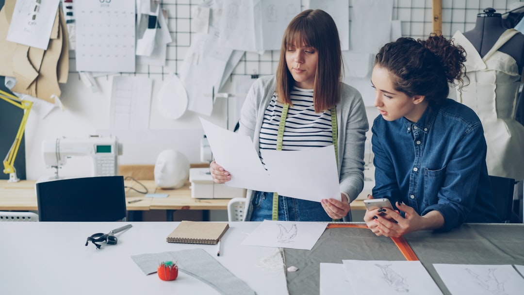 Two women discuss designs in a workshop.